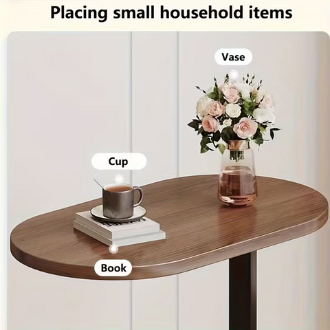 Wooden walnut oak oval side table beside sofa